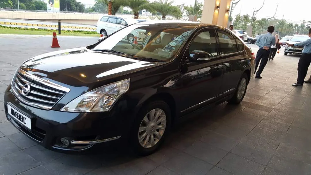 Black Nissan Teana waiting at a hotel entrance