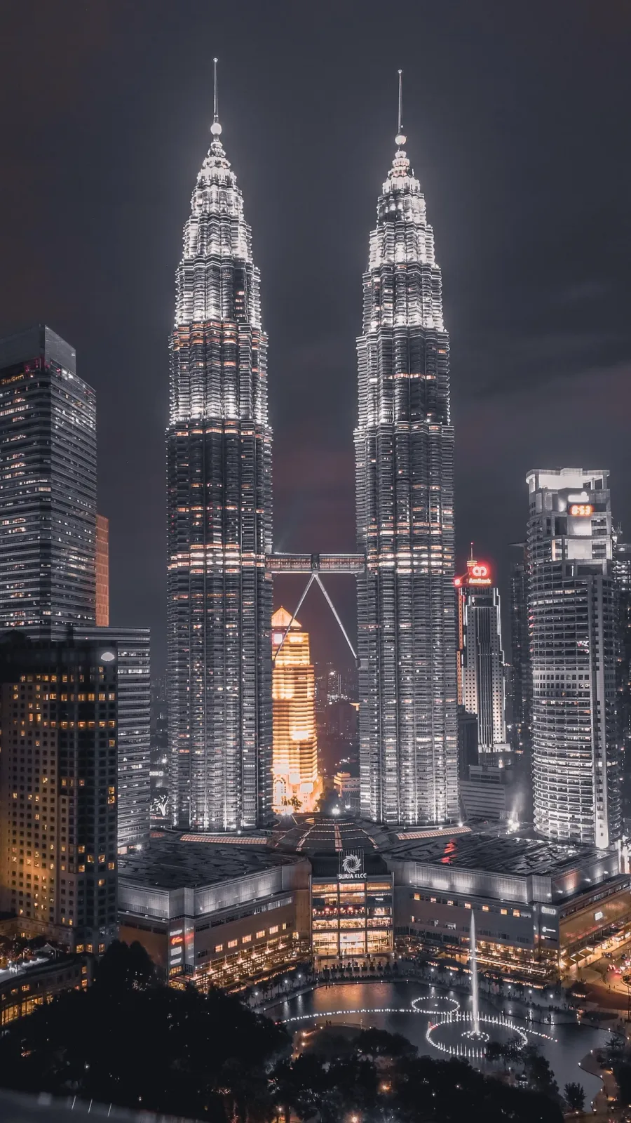 Petronas Twin Towers lit up at night above Suria KLCC and the fountains, Kuala Lumpur