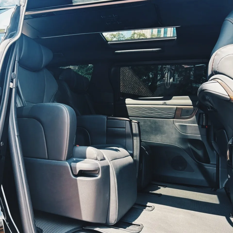Black leather captain seats in the rear cabin of a premium chauffeur car